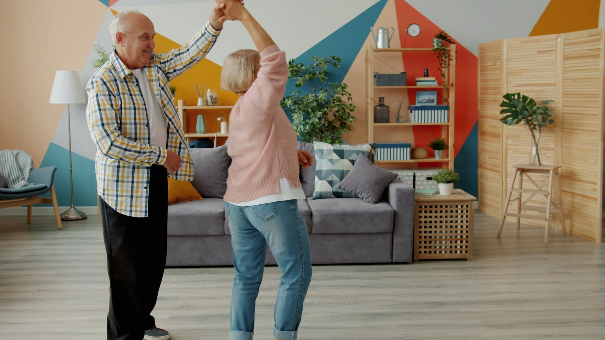 Senior couple dancing in the living room of their new home