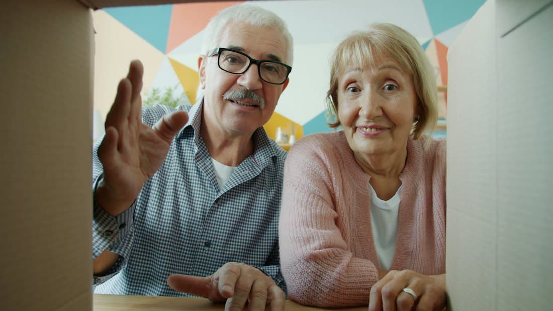 Senior couple unpacking a moving box together